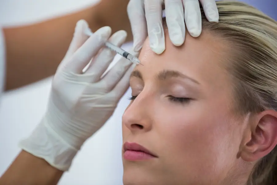 Aesthetic professional administering Botox and dermal fillers to a client, demonstrating the science behind anti-aging injectables in a medical spa setting.